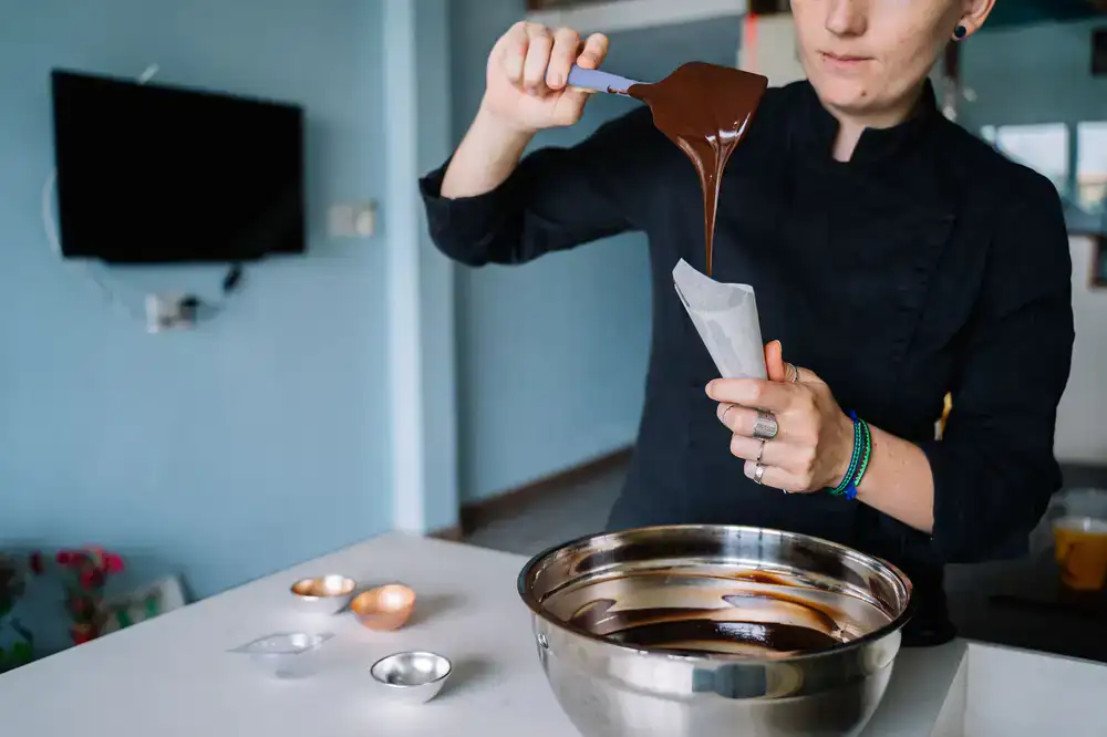 Hands working with chocolate tools